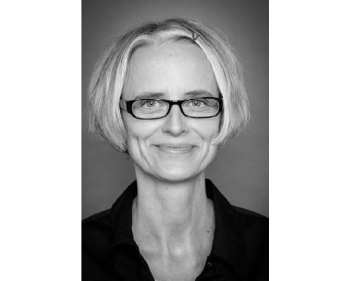 schwarz-weiss Foto einer blonden kurzharringen Frau mit Brille