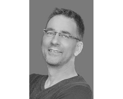 schwarz-weiss Foto eines Mannes mit kurzen Haaren und Brille