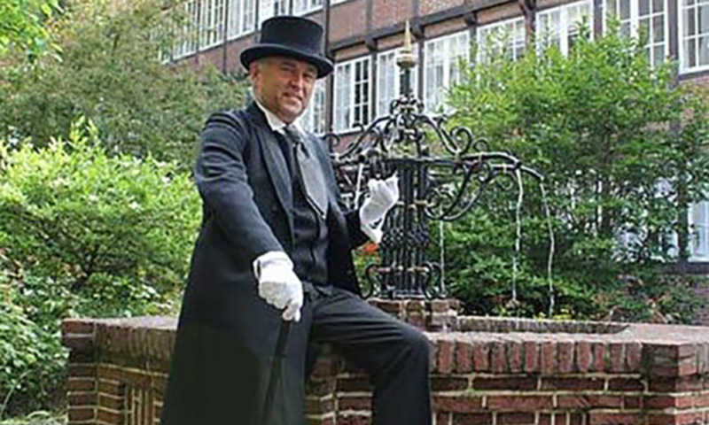 Mit schwarzen Anzug und Zylinder bekleideter Fuehrer einer "Gewuerztour" durch Hamburg