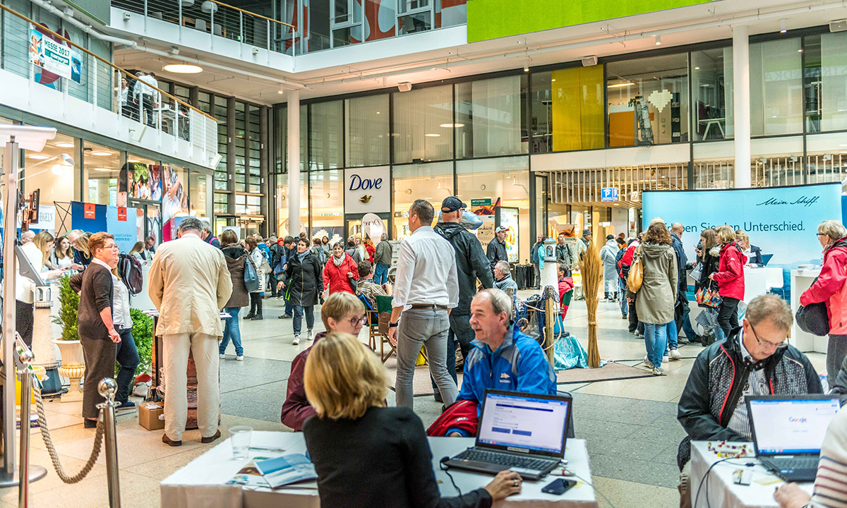 Besucher erkunden die Messestaende auf der Kreuzfahrt-Messe