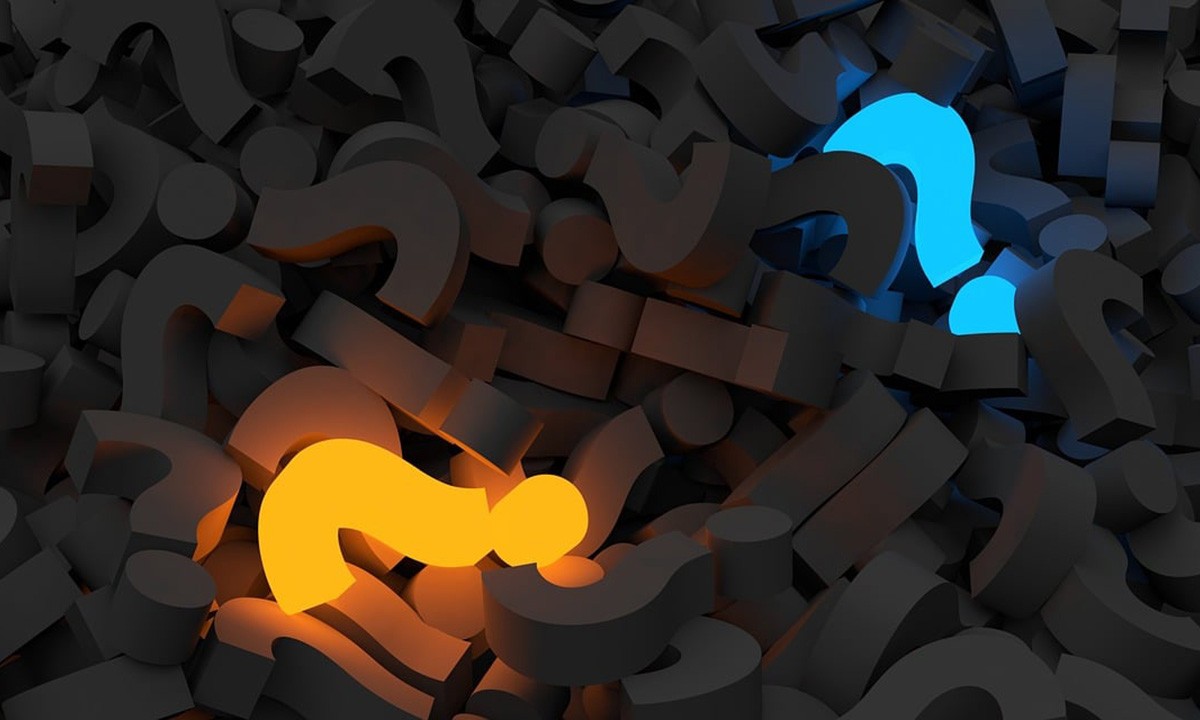 Symbolbild: 3D-Render eines Haufens grauer Fragezeichen. Dazwischen leuchtet ein Fragezeichen orange und eines hellblau.